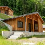 Cozy wooden cabins nestled in a lush forest, perfect for a rural vacation.